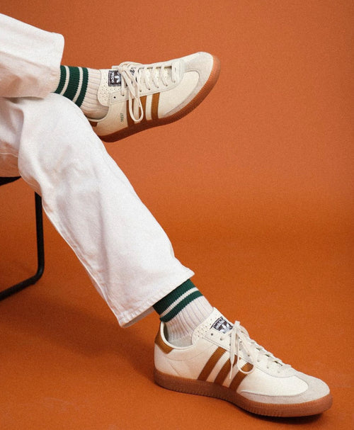 A pair of Cream and Green striped socks being worn with vintage adidas sneakers
